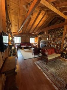 een woonkamer met een bank, een tv en boeken bij MACKINNEY CAMP - LIMIT 8 cottage in Standish