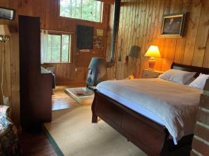 a bedroom with a bed and a tv in it at MACKINNEY CAMP - LIMIT 8 cottage in Standish