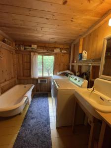 een badkamer met een bad en een wastafel bij MACKINNEY CAMP - LIMIT 8 cottage in Standish