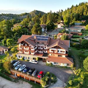 an aerial view of a house with cars parked in a parking lot at Hotel La Cumbrecita in La Cumbrecita