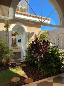 a garden in a house with an archway and plants at Hotel Oeste Plaza in Andradina