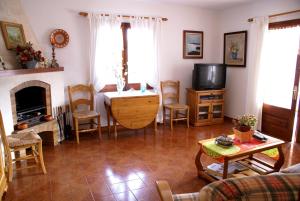 sala de estar con mesa y TV en Villa Ponderosa, en Cala Blanca