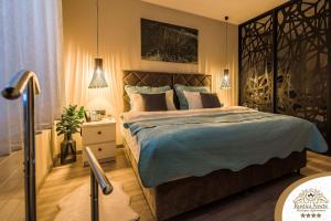a bedroom with a large bed with blue sheets and pillows at Rustica Nocte Boutique Apartments in Požega