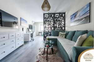 un soggiorno con un divano blu e un tavolo di Rustica Nocte Boutique Apartments a Požega