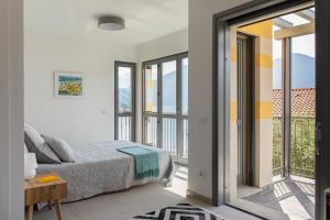 a bedroom with a bed and a balcony at Casa degli Ulivi - Ossuccio - Tremezzina in Isola Comacina