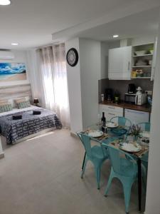 a kitchen with a table and chairs and a bedroom at APARTAMENTOS ELEMAR free luggage storage in Málaga
