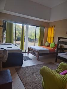 sypialnia z 2 łóżkami i dużym oknem w obiekcie Campestre House w mieście Alto Boquete
