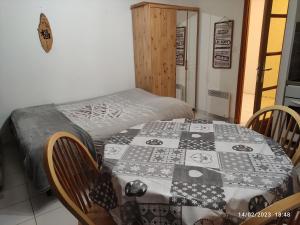 ein Schlafzimmer mit einem Tisch und einer Decke darauf in der Unterkunft Studio vue sur lac et montagne in Savines