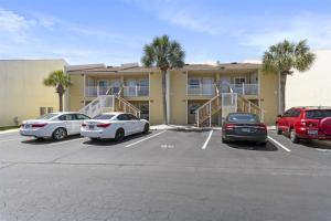 a parking lot with cars parked in front of a building at 8 G Two Bedroom Condo in Destin