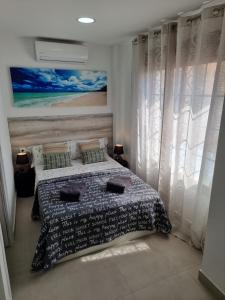 a bedroom with a bed and a painting on the wall at APARTAMENTOS ELEMAR free luggage storage in Málaga