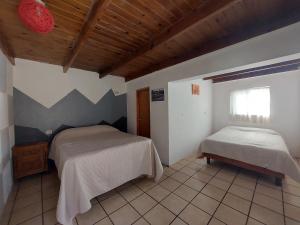 a bedroom with two beds and a window in it at Casa Nopal Tu casa vacacional tipo hotel in Creel