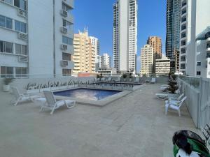 a patio with chairs and a pool in a city at Delfin 207 in Cartagena de Indias