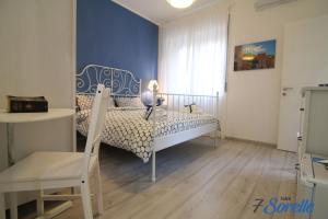 a bedroom with a bed and a table and a chair at "7 SORELLE B&B" camere in pieno centro città con bagno privato, FREE HIGH SPEED WI-FI, NETFLIX in Cosenza