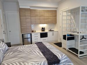 1 dormitorio con 1 cama grande y cocina en Hampton on Washington - FREE Wifi and Netflix en Goolwa