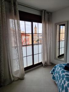 a bedroom with a large window with a view of a building at APARTAMENTOS ELEMAR free luggage storage in Málaga