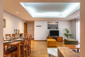 a dining room with a table and a television at Machico City Apt in Machico
