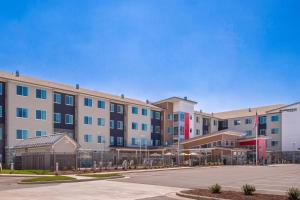 a large apartment building with a parking lot at Residence Inn by Marriott Charlotte Steele Creek in Charlotte