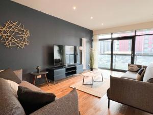 a living room with a couch and a flat screen tv at Lovely two bed apartment in Finnieston in Glasgow