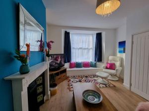 uma sala de estar com um sofá e uma mesa em Cheerful 3 bedroom home with garden! em Torquay
