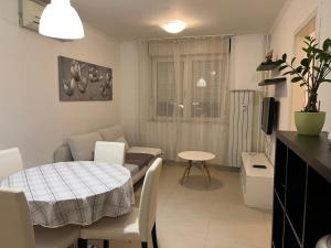 a kitchen and living room with a table and a couch at Apartments Flores in Zagreb