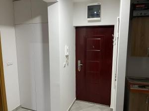 uma cozinha com uma porta castanha e um frigorífico em HG apartment em Jelah