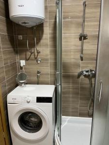 uma pequena casa de banho com uma máquina de lavar roupa e um WC em HG apartment em Jelah