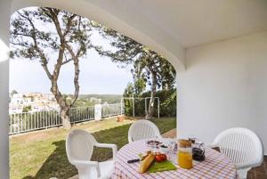 una mesa con un plato de fruta en el patio en Villa Verano, en Cala Galdana