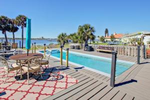 a deck with a table and chairs next to a pool at 3170 S Peninsula Drive in Daytona Beach