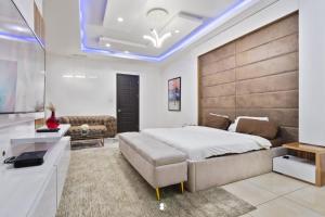 um quarto com uma cama grande e um sofá em Sophisticated 4-Bedroom Condo in VI em Igboshere