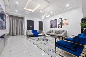 a living room with couches and a table at Sophisticated 4-Bedroom Condo in VI in Igboshere