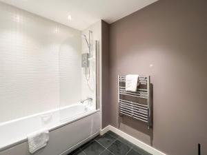 a bathroom with a tub and a shower and a sink at Lovely two bed apartment in Finnieston in Glasgow