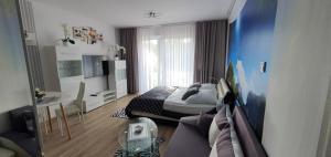 a bedroom with a bed and a living room at Pobierowo Apartament Słoneczny A208 przy samym morzu in Pobierowo