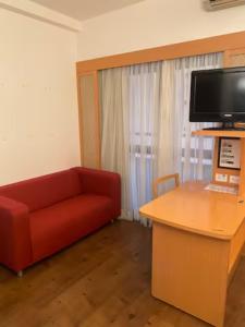 - un salon avec un canapé rouge et un bureau dans l'établissement Flat com sacada e piscina, à São Paulo