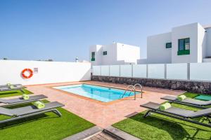 basen z leżakami obok budynku w obiekcie Villa Fula w mieście Playa Blanca