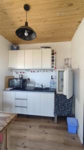 cocina con armarios blancos y techo de madera en Casa Cerro Arco en Mendoza
