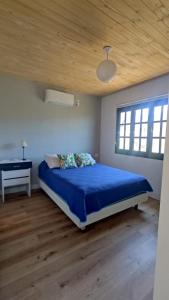 a bedroom with a blue bed and a piano at Casa Cerro Arco in Mendoza