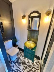 a bathroom with a sink and a toilet and a mirror at Fortescue Lodge in Bournemouth