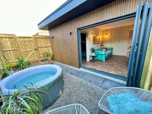 patio trasero con bañera de hidromasaje y sillas y patio en Fortescue Lodge, en Bournemouth