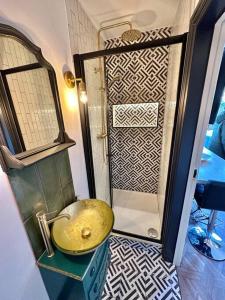 y baño con lavabo de oro y ducha. en Fortescue Lodge en Bournemouth