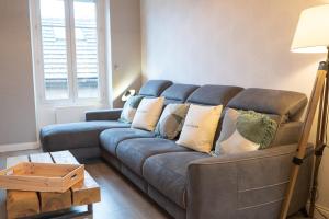 a living room with a blue couch with pillows at Le 11 à 5 min de l'hypercentre d'Epernay 6 personnes in Épernay +18 photos