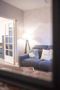 - un salon avec un canapé bleu et une fenêtre dans l'établissement Le 11 à 5 min de l'hypercentre d'Epernay 6 personnes, à Épernay