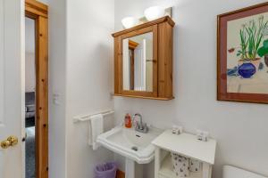 a bathroom with a sink and a mirror at Peaceful Cottage in Gearhart +42 photos