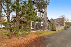 a house with a tree in front of it at Peaceful Cottage in Gearhart