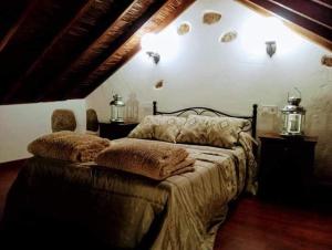 a bedroom with a bed with two pillows on it at Rural Suite Santiago de Tunte in San Bartolomé de Tirajana