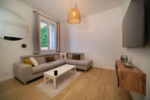 uma sala de estar com um sofá e uma mesa em Appartement climatisé grande terrasse 2 chambres em Marselha