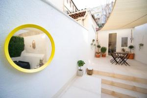a round yellow mirror on the side of a white wall at Appartement climatisé grande terrasse 2 chambres in Marseille