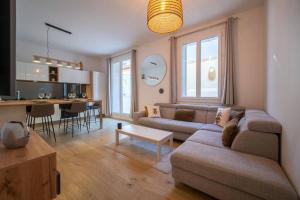 uma sala de estar com um sofá, uma mesa e uma cozinha em Appartement climatisé grande terrasse 2 chambres em Marselha