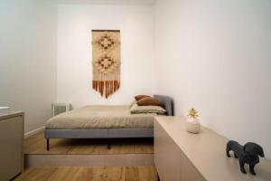 um pequeno quarto com uma cama e uma parede em Appartement climatisé grande terrasse 2 chambres em Marselha
