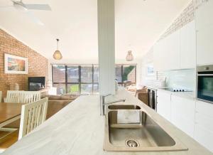 a kitchen with a sink and a counter top at Coconuts - 3 bedroom 3 bathroom townhouse with tennis court in Nelson Bay