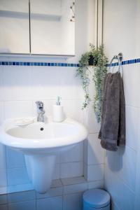 a bathroom with a white sink and a toilet at Comfy 3 bedroom cottage super fast wifi, paid parking in Reading